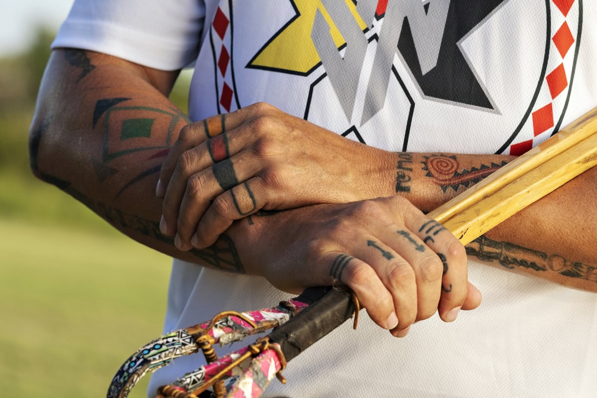 Dewayne Hornbuckle shows off his arm paint and decorated stickball sticks