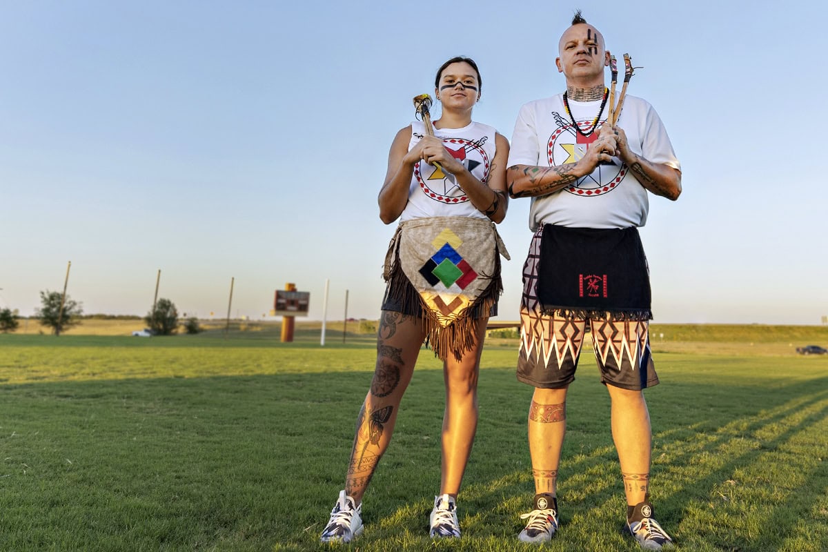 Kyra and Dewayne Hornbuckle pose in a field with full stickball regalia