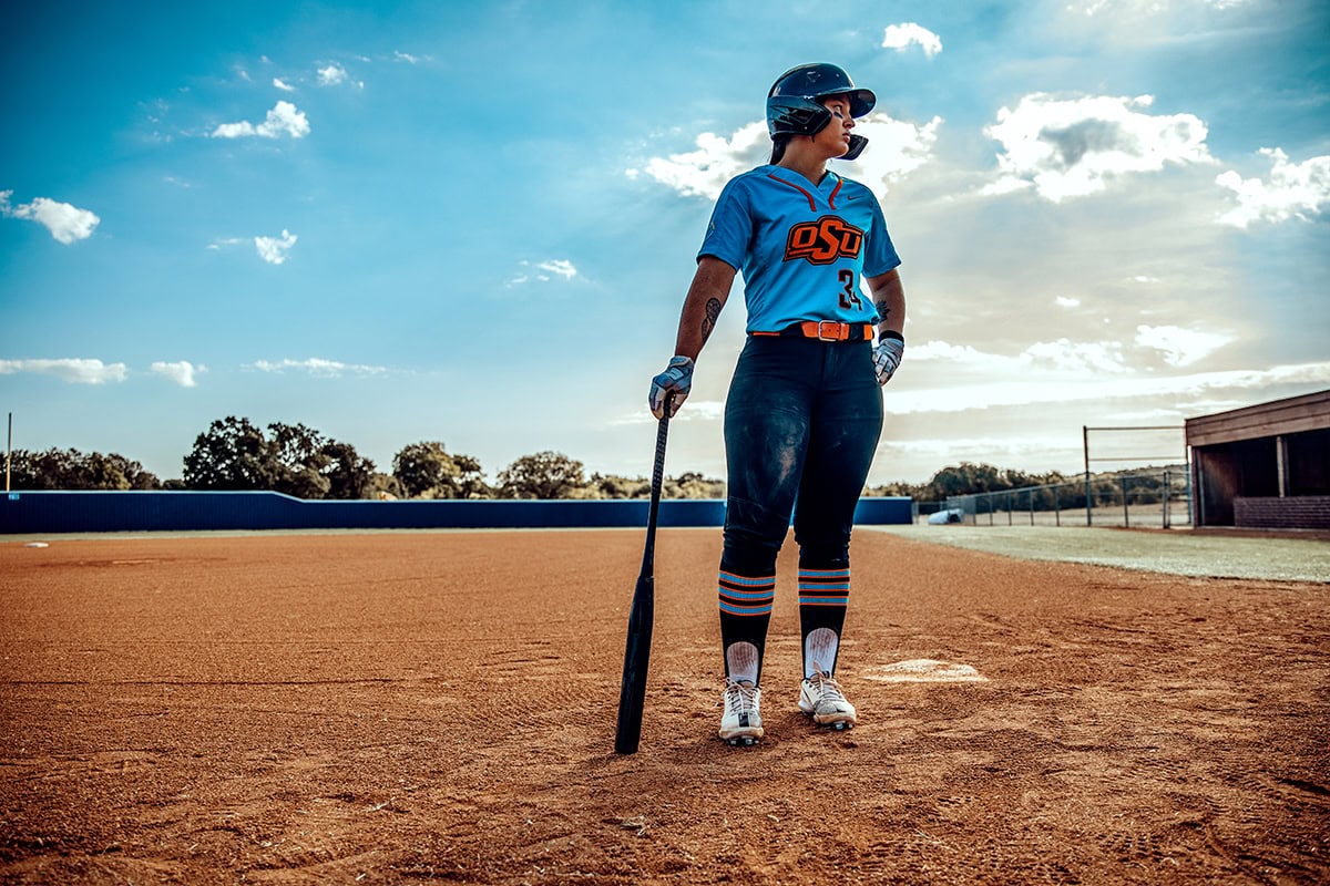 Michaela Richbourg stands on a softball diamond in her full OSU uniform