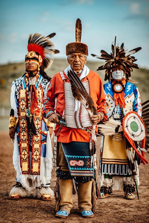 Wilson Roberts and two other people stand in traditional clothing
