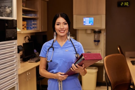 Tara Thorpe at the nurses's station holding a binder