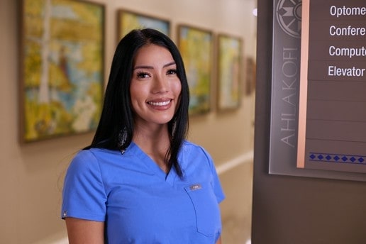 Tara Thorpe smiles in her blue scrubs