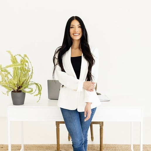 Tara Thorpe smiles in front of a white desk