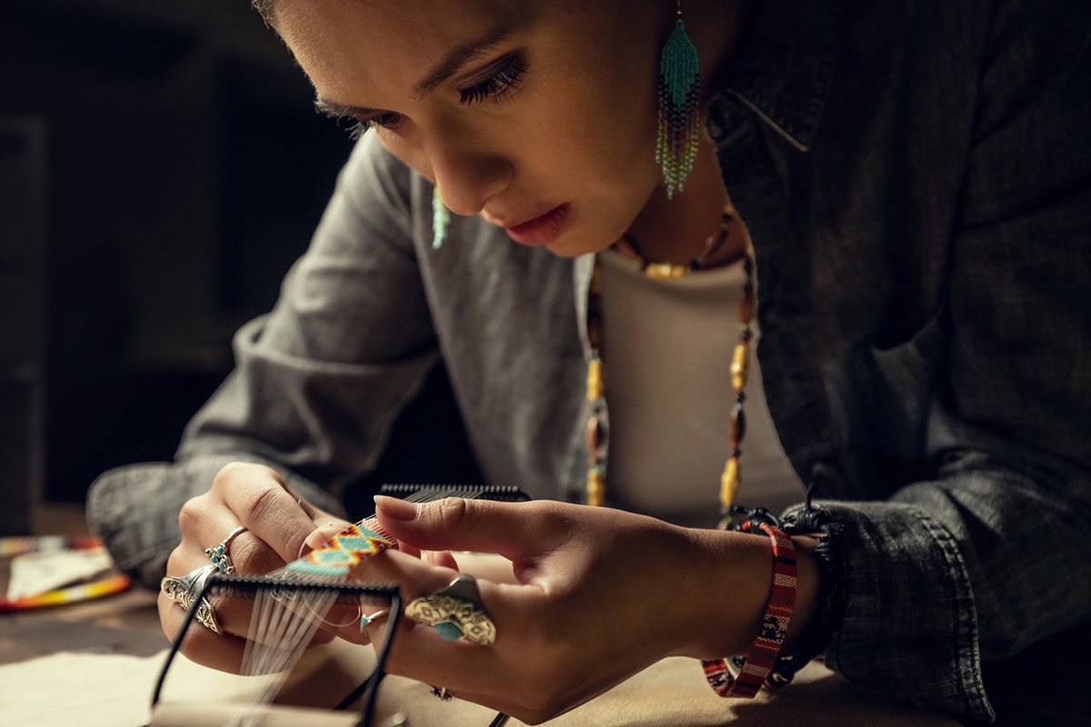 Jula Harjo concentrates as she adds beads to her jewelry