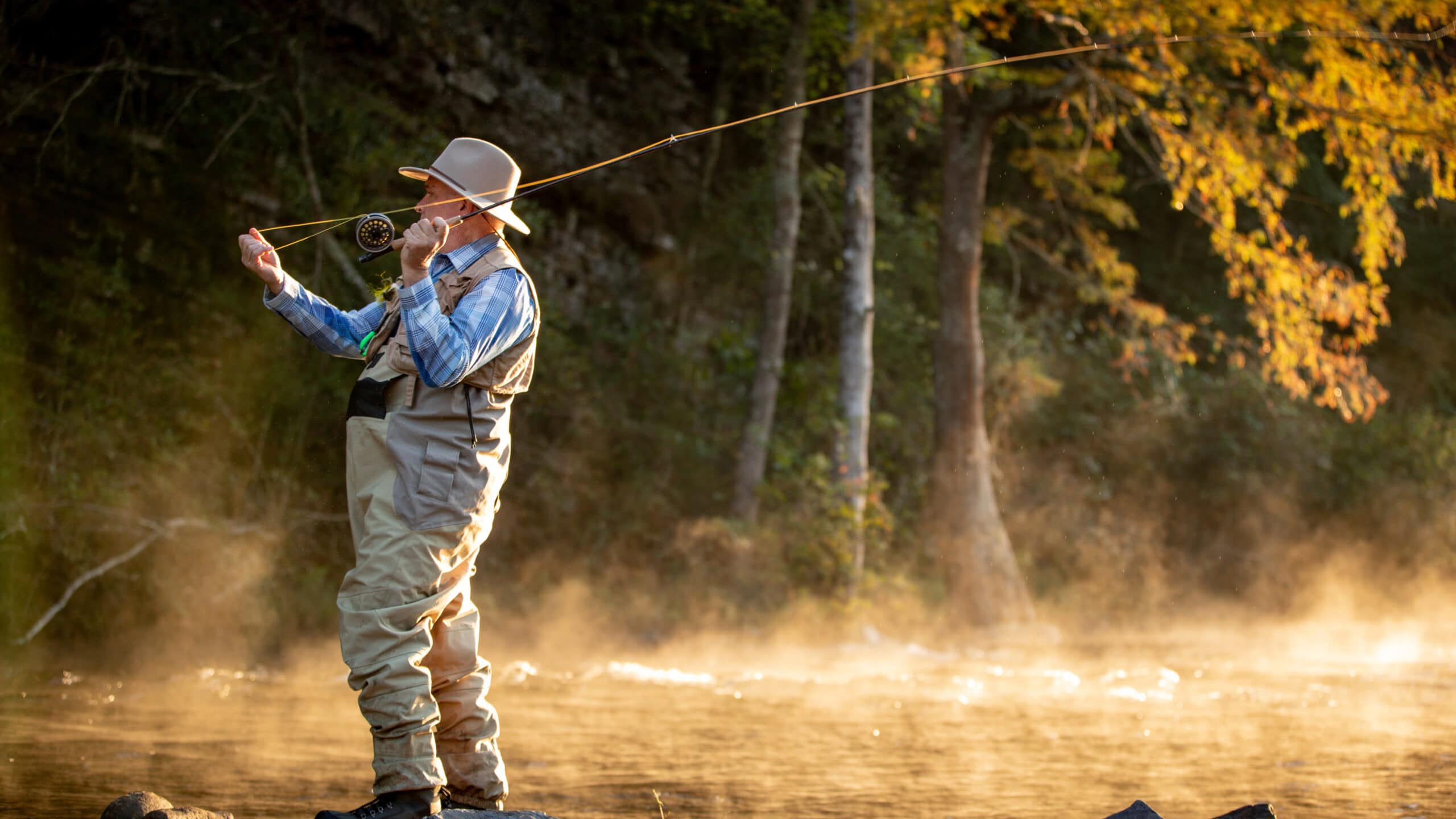 Grant Brittan casts a fishing line into a river