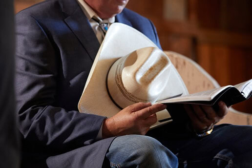 Mike Mings holds his cowboy hat and Bible in his hands