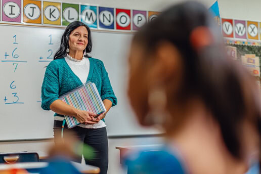 Stephanie Roberts in her classroom. The foreground contains a student, out of focus.