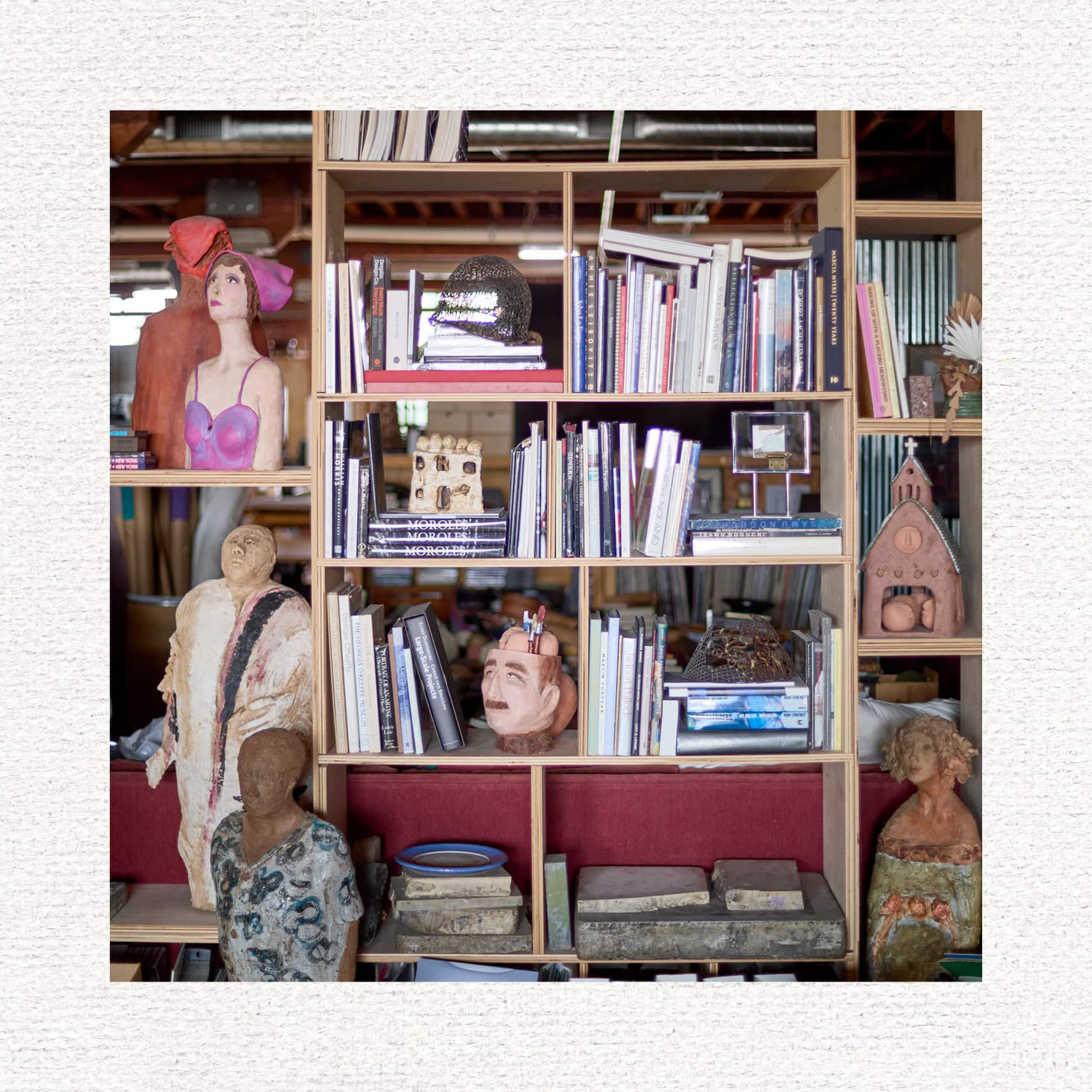 A bookshelf with books and miscellaneous scultpures