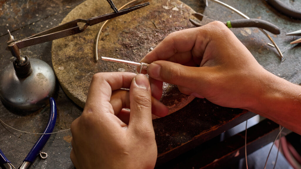 Supportive woman standing outside community center with Together We’re More sign.