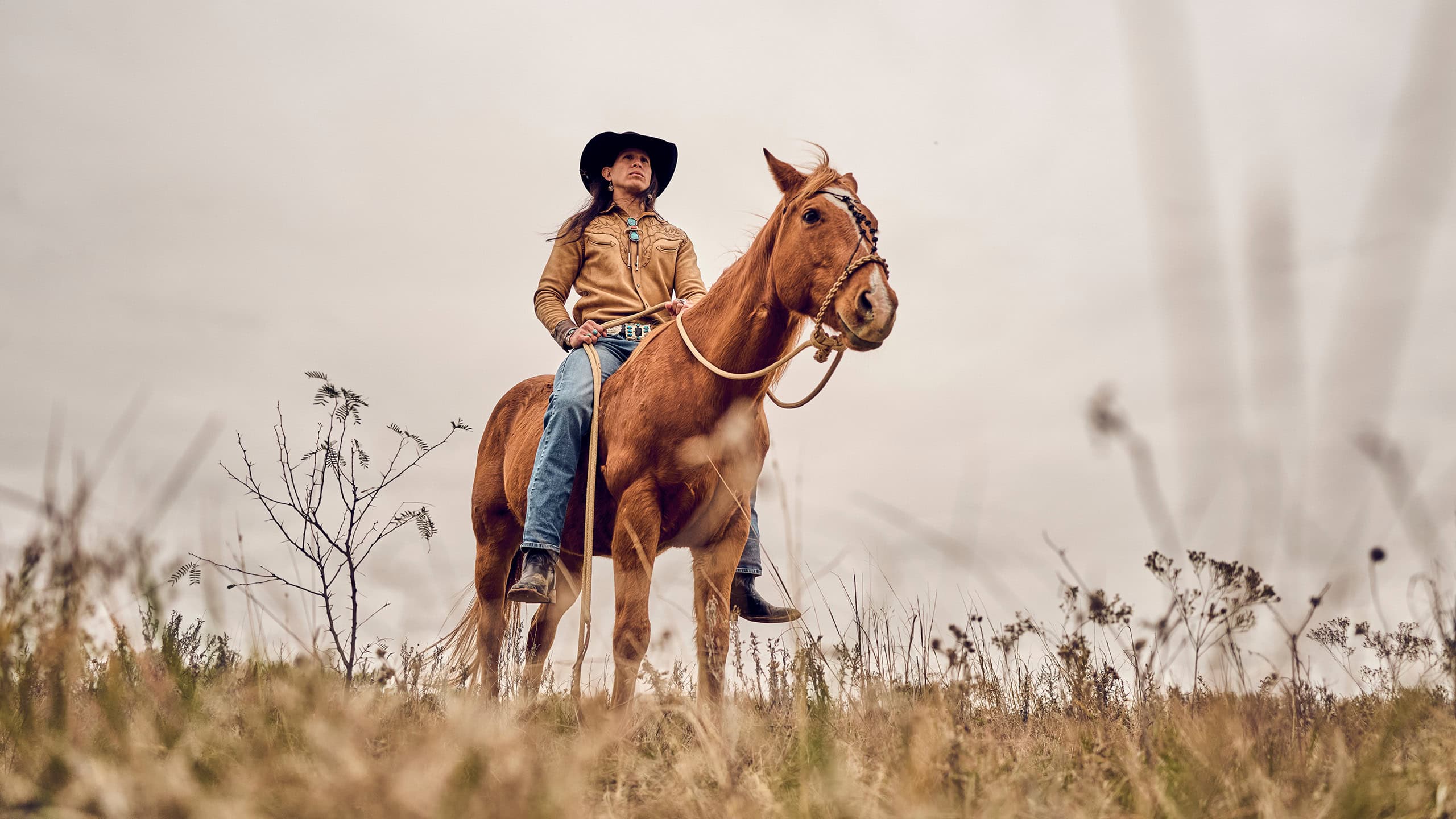 JP Guana riding a horse in a field.